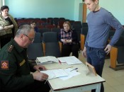 Начальник отделения призыва В.Н. Большаков изучает личное дело призывника