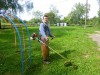 Владислав Александрович Павлов обкашивает траву на территории Холязинского детского сада