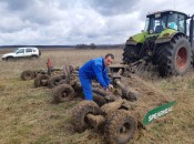 Механизатор ННПП  Александр Моденов очищает кустарниковую косилку от ветвей