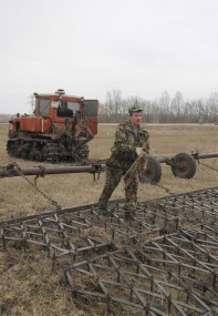 По словам механизатора Сергея Рыбина, бороны пока еще забиваются сырой травой