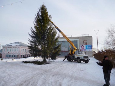 Рабочие поселковой администрации устанавливают главную елку поселка на площади перед РДК