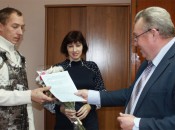 Семья Реуновых получает долгожданное свидетельство на приобретение жилья из рук главы администрации района Н.А. Белякова