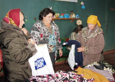 Специалист по соцработе Татьяна Ивановна Школина (в центре)  помогает жителям Курлакова выбрать одежду по сезону — теплые кофты, куртки, пальто.